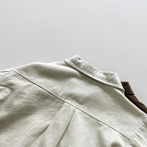 Détail de l'empiècement dos et du col sur une chemise en sergé beige enfant