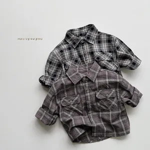 Flat lay detail of kids plaid shirts showing cotton texture and front flap pockets