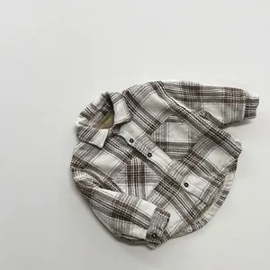 Detailed close-up of brown and beige plaid flannel shirt featuring dual chest pockets