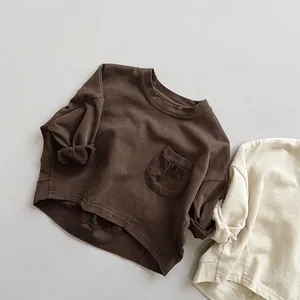 Détail de t-shirts en coton amples pour enfants avec col rond et poche plissée en marron et beige