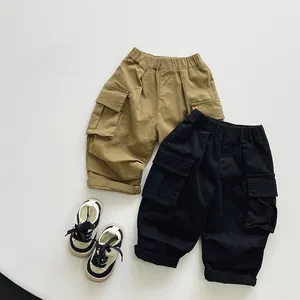Dettaglio dei pantaloni cargo per bambini con vita elastica e grandi tasche a patta kaki e nere