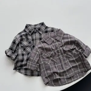 Detail of classic plaid cotton shirts for kids featuring dual chest pockets and soft texture