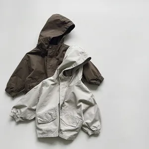 Detailed flat lay of children's hooded windbreakers in dark brown and beige cotton fabric
