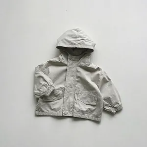 Close-up of beige hooded jacket featuring large cargo pockets and elastic cuffs