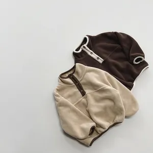 Flat lay detail of soft fleece texture and button collar on kids warm sweaters