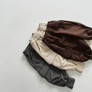 Close-up of kids joggers in dark gray, cream, and coffee colors with cargo pockets