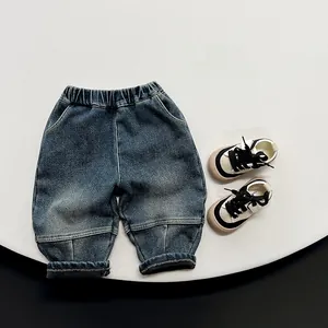Detailed close-up of kids fleece-lined denim pants with elastic waist and rolled-up cuffs