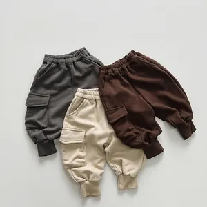 Detail view of kids cargo sweatpants with side pockets in grey, beige and brown