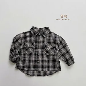 Detailed close-up of boys classic plaid flannel shirt with front button pockets