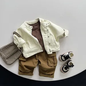 Completo bambino con giacca di jeans beige, pantaloni cargo e felpa marrone distesa