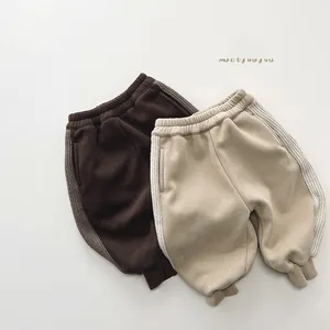 Détail de pantalon d'hiver doublé pour enfants avec bandes latérales et bords-côtes