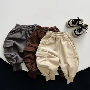 Detailed view of kids cargo sweatpants in dark grey, brown and beige tones
