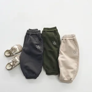Détails de trois joggers doublés en polaire avec bords-côtes et broderie d'étoile