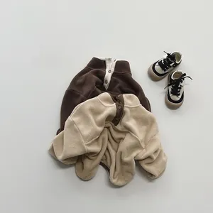 Detailed flat lay of soft fleece children sweatshirts in coffee and beige with baby shoes