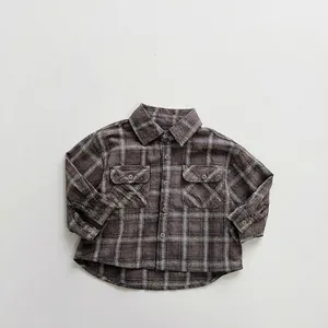 Detailed flat lay of children's plaid shirt with classic chest pockets and cotton texture