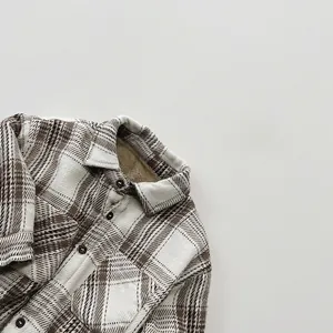Close-up of kids plaid flannel shirt with warm fleece lining and classic brown buttons