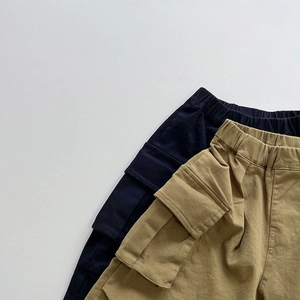 Dettaglio vita elastica e tasche cargo laterali su pantaloni bimbi neri e color kaki