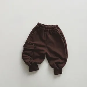 Detail of dark brown kids cargo sweatpants with elastic waist and side flap pocket