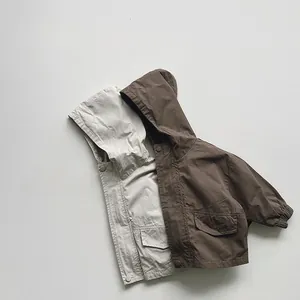 Detailed view of kids hooded jackets in cream and coffee with snap buttons and pockets