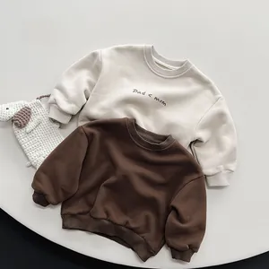 Close-up of cream and brown children sweatshirts featuring Dad mom printed text