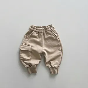 Close-up of beige knitted cargo sweatpants for kids featuring an elastic waist and side pocket