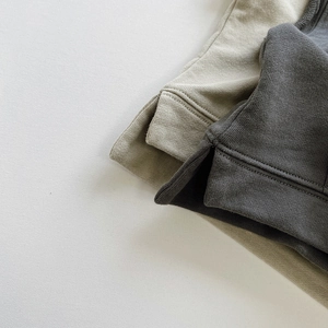 Dettaglio degli spacchi laterali e della trama a maglia fitta sui gilet per bambini
