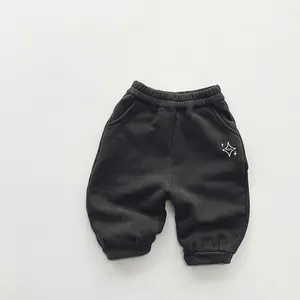 Détail du jogging enfant gris foncé avec taille élastique et imprimé étoile décoratif
