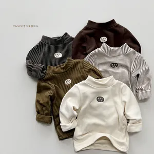 Detail showing assorted kids' fleece-lined turtlenecks in solid and striped knit fabrics