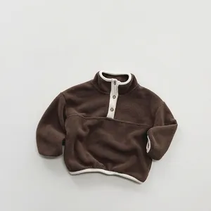 Close-up of children's fleece pullover with buttoned stand collar and contrast trim
