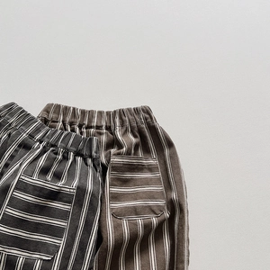 Detailed close-up of boys striped cotton trousers with elastic waist and back pockets