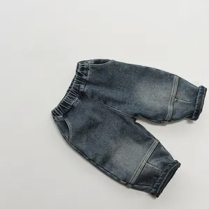 Detail of kids washed denim trousers with elastic waistband and folded cuffs