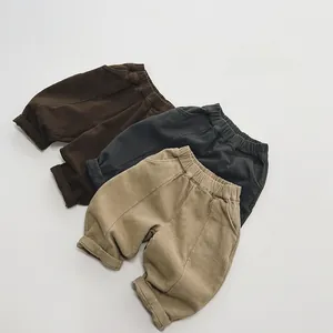Flat lay of three pairs of kids' fleece-lined joggers in brown, charcoal, and khaki tones