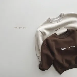 Detail of cream and chocolate fleece sweatshirts with Dad less than Mom print for kids