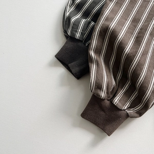 Close-up of vertical striped cotton pants with elastic ribbed cuffs in black and brown