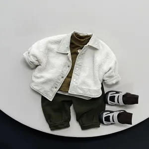 Flat lay of kids winter warm set with white fleece jacket and olive green trousers