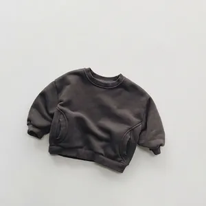 Detailed close-up of dark grey fleece sweatshirt showing ribbed cuffs and side pockets