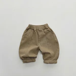 Close-up of children's khaki fleece trousers with elastic waist and large curved pockets