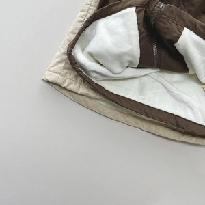 Detail of kids cargo vest showing warm white faux fleece lining and windproof fabric