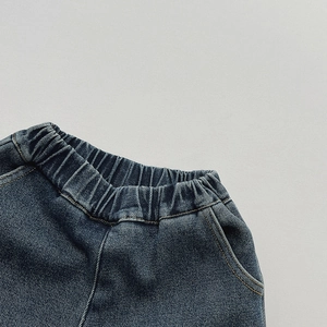 Detailed close-up of dark blue boys jeans showing elastic waistband and stitching