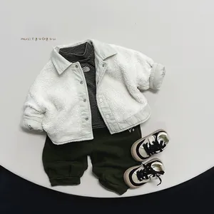 Flat lay of kids winter set featuring white fleece jacket and green joggers