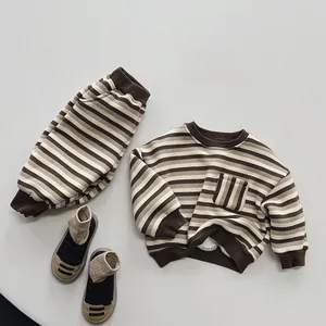 Flat lay of kid's Korean-style striped warm sweatshirt and matching joggers set in brown