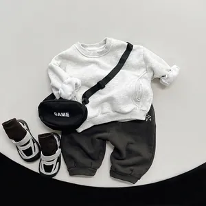 Kids grey fleece sweatshirt and joggers set with GAME chest bag on minimal display