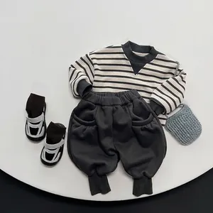 Winter striped long-sleeve sweatshirt and dark grey joggers set for kids on white platform