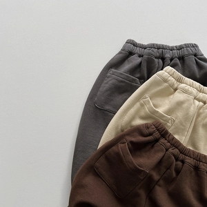 Three pairs of kids casual cotton sweatpants in dark grey, beige, and brown colors