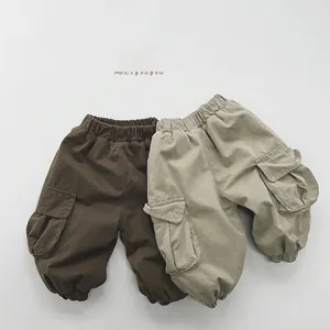 Detail of elastic waistbands and cargo pockets on brown and khaki boys pants