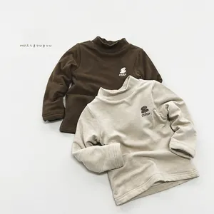 Detail of kids fleece lined mock neck tops in brown and grey with color text embroidery
