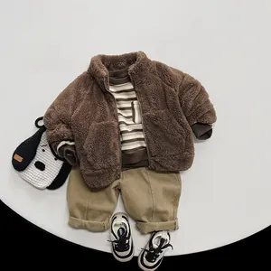 Detailed flat lay of children's brown fleece jacket with striped top and khaki trousers