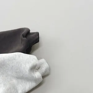 Detail of ribbed cuffs on fleece-lined sweatshirts for toddlers in dark and light grey