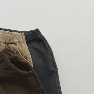 Detail of fleece-lined kids' trousers with elastic waistband and soft twill texture