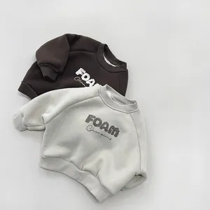 Detail view of thick fleece sweatshirts for kids in coffee and beige with FOAM print